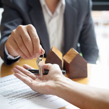 real estate professional handing over keys to a client for their new house - reputation management for real estate professionals