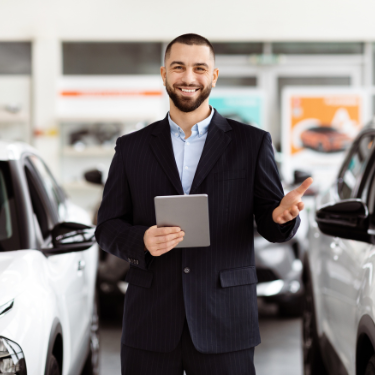 car salesman standing in fro -nt of cars review management for automotive