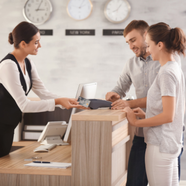 hospitality professional helping customers at counter - review management for hospitality
